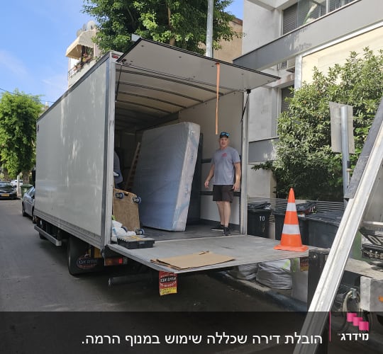 משאית פתוחה עם מזרן וקרטונים להובלה